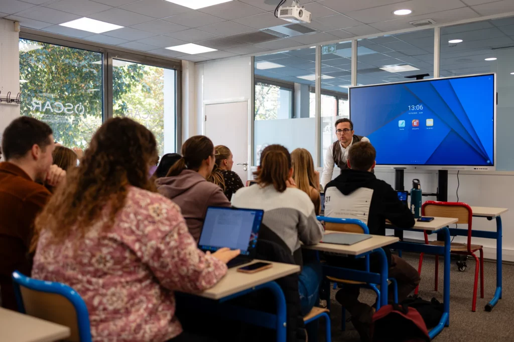 Formateur animant un cours devant un tableau interactif à l'école OSCAR
